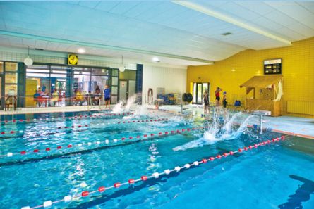 Schwimmhalle Schwimmer springen ins Wasser